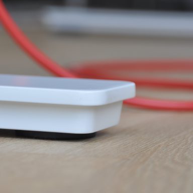 Weißer Tischfuß mit rotem Kabel