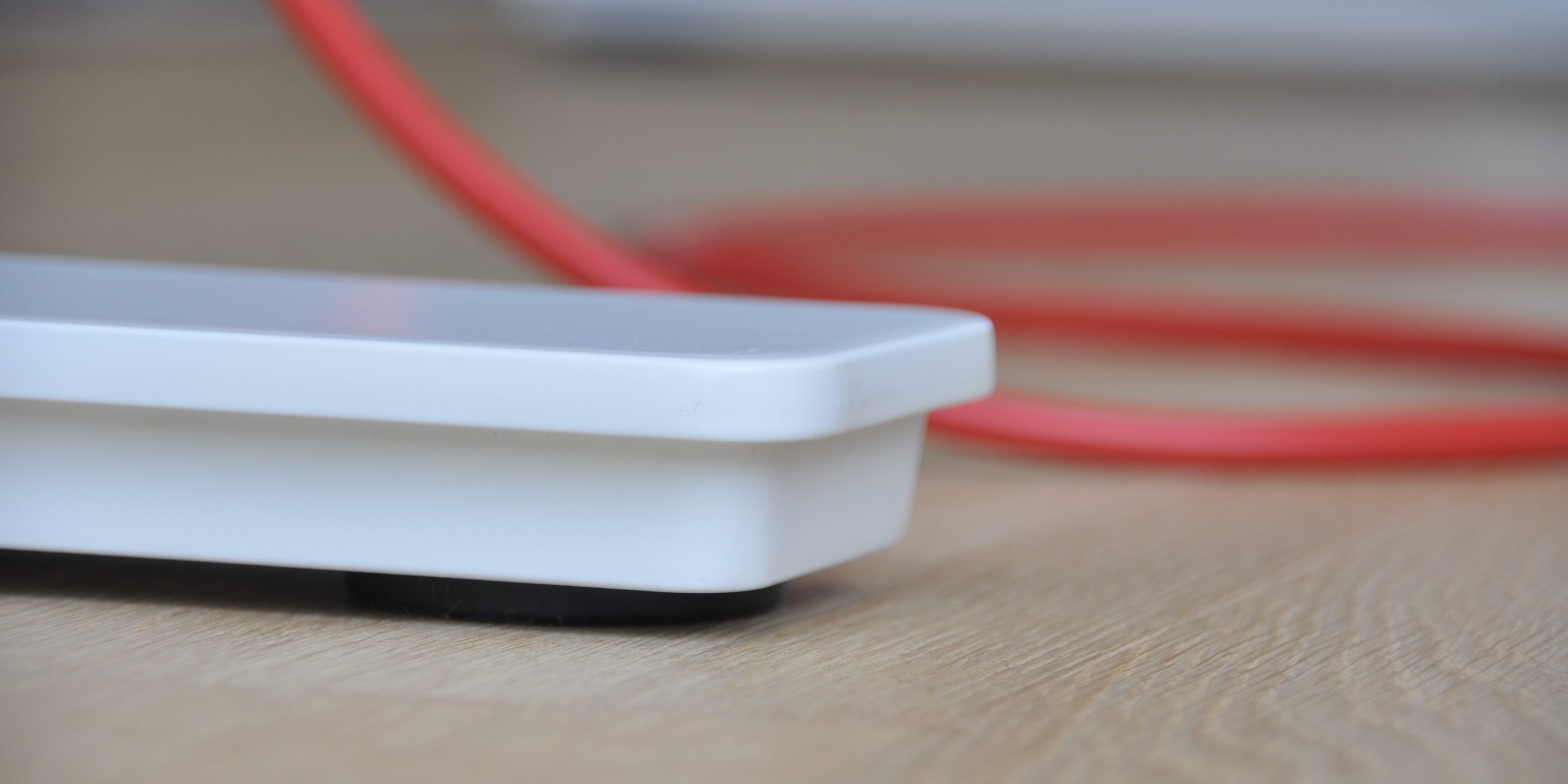 Weißer Tischfuß mit rotem Kabel Weißer Tischfuß mit rotem Kabel
