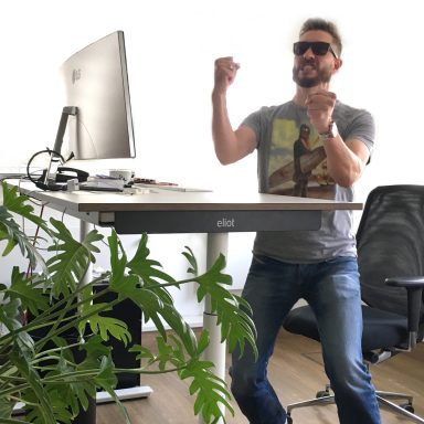 Jubelnder Mann vor eliot Schreibtisch.