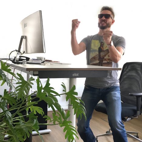 Jubelnder Mann vor eliot Schreibtisch.