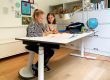 Kinder in Kinderzimmer mit höhenverstellbarem Schreibtisch.