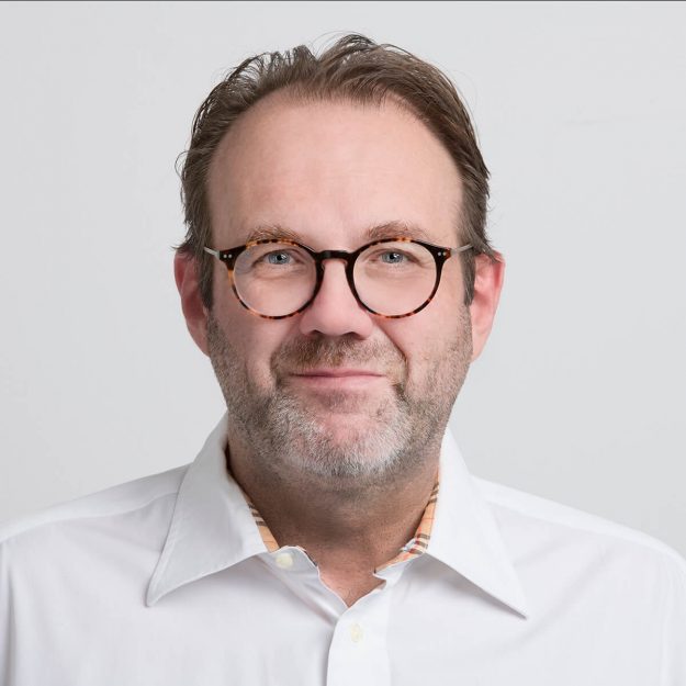 Profilbild eines Mitarbeiters in weißem Hemd