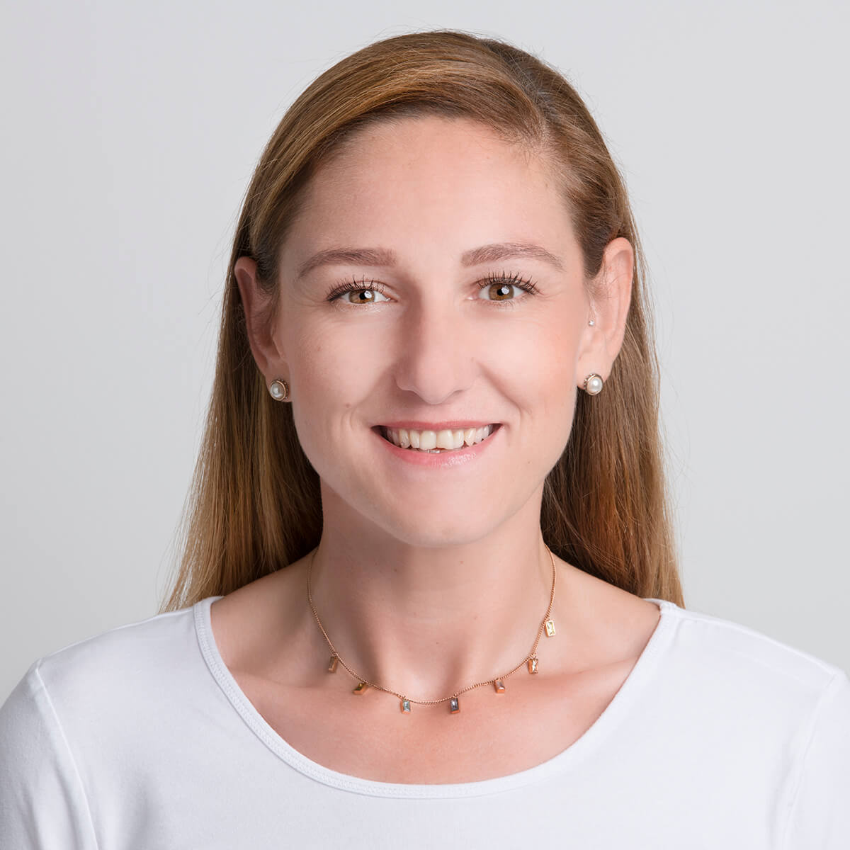 Profilbild einer Mitarbeiterin in weißem Oberteil