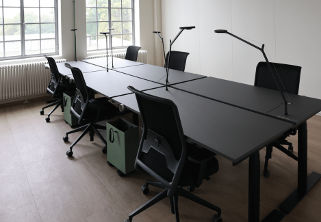 Offene Büros mit höhenverstellbaren Schreibtischen und Stühlen und Lampen.