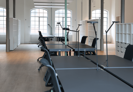 Offene Büros mit höhenverstellbaren Schreibtischen und Stühlen und Lampen.