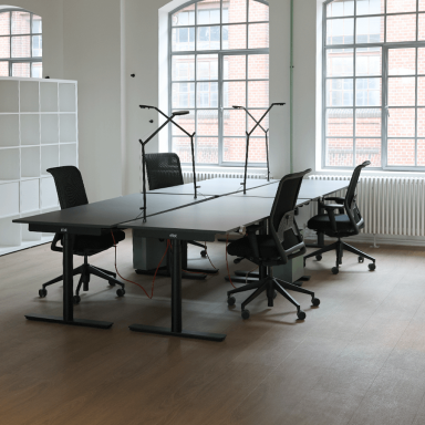 Offene Büros mit höhenverstellbaren Schreibtischen und Stühlen und Lampen.