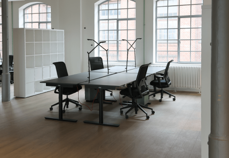 Offene Büros mit höhenverstellbaren Schreibtischen und Stühlen und Lampen.