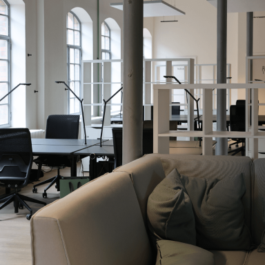 Offene Büros mit höhenverstellbaren Schreibtischen und Stühlen und Lampen.