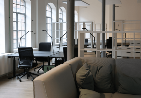 Offene Büros mit höhenverstellbaren Schreibtischen und Stühlen und Lampen.