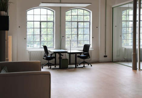 Offene Büros mit höhenverstellbaren Schreibtischen und Stühlen und Lampen.