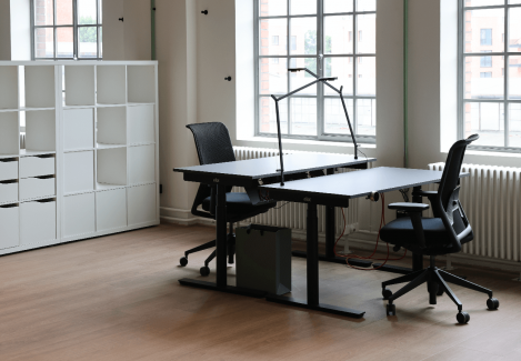 Offene Büros mit höhenverstellbaren Schreibtischen und Stühlen und Lampen.