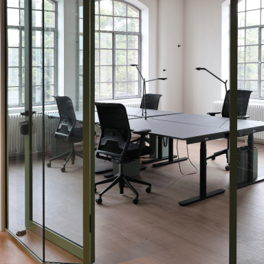 Offene Büros mit höhenverstellbaren Schreibtischen und Stühlen und Lampen.