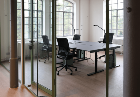 Offene Büros mit höhenverstellbaren Schreibtischen und Stühlen und Lampen.