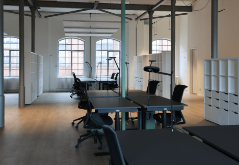 Offene Büros mit höhenverstellbaren Schreibtischen und Stühlen und Lampen.