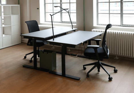 Offene Büros mit höhenverstellbaren Schreibtischen und Stühlen und Lampen.