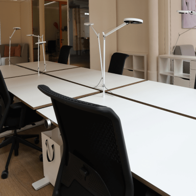 Offene Büros mit höhenverstellbaren Schreibtischen und Stühlen und Lampen.