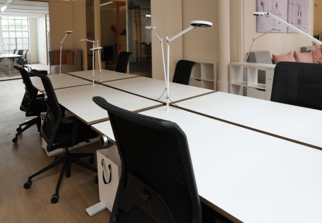 Offene Büros mit höhenverstellbaren Schreibtischen und Stühlen und Lampen.