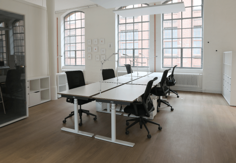 Offene Büros mit höhenverstellbaren Schreibtischen und Stühlen und Lampen.