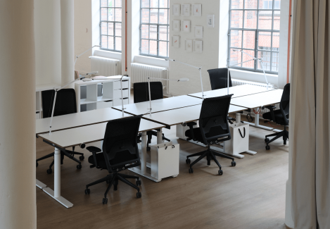 Offene Büros mit höhenverstellbaren Schreibtischen und Stühlen und Lampen.